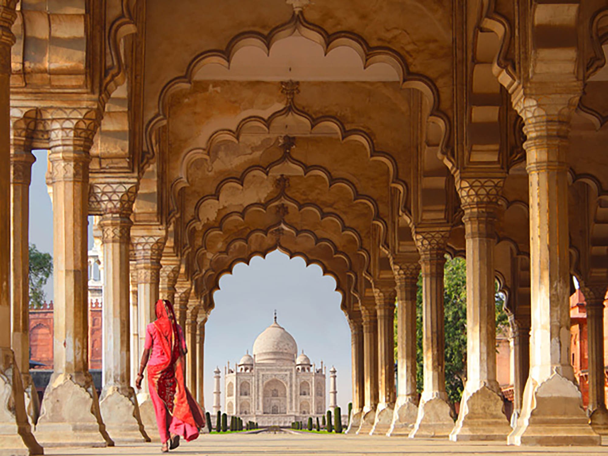 Mujer con sari tradicional caminando hacia el Taj Mahal