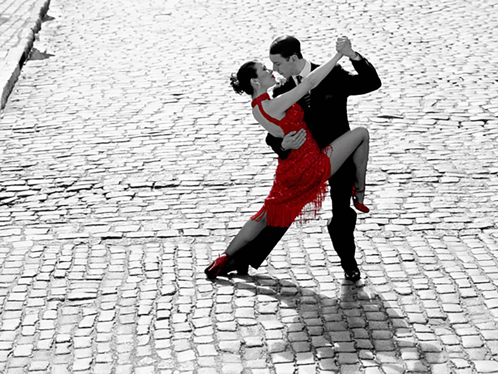 Pareja bailando tango en una calle adoquinada
